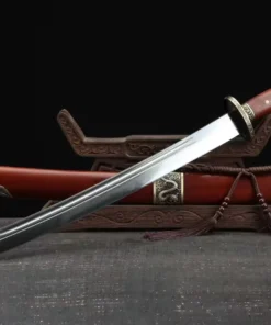 A Chinese curved Short sword, displayed next to its scabbard, leaning against a small wooden stand.