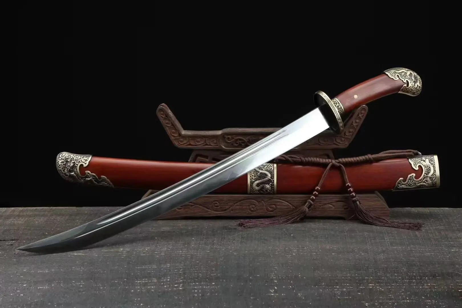 Curved Short Sword A Chinese curved Short sword, displayed next to its scabbard, leaning against a small wooden stand.