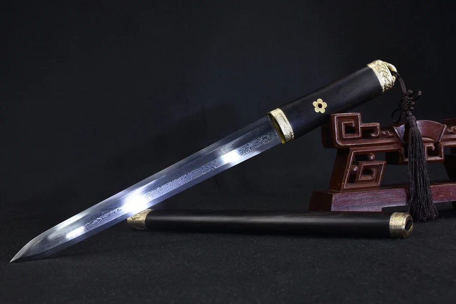 Dagger Knife A Chinese dagger knife with a double-edged blade, displayed alongside its brown Ebony wood sheath, leaning against a small wooden stand.
