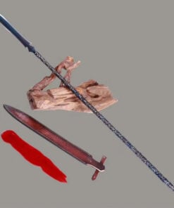 A long double edged spear leaning on a small wood log, with its scabbard and red tassel next to it on the floor.