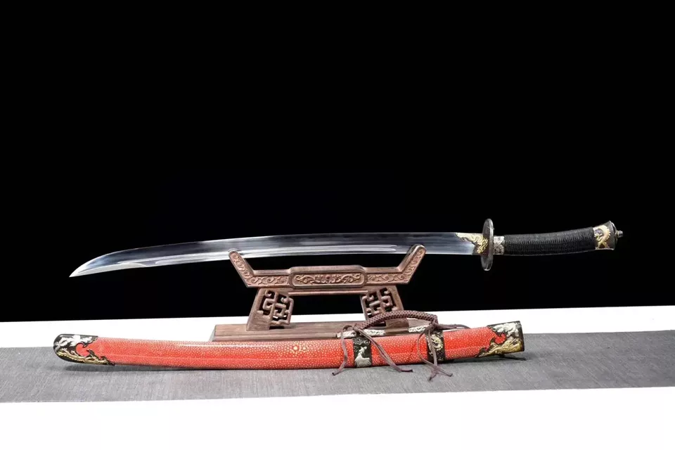 Liuyedao Sword A Chinese Liuyedao sword saber, displayed on a small wooden stand, with its scabbard below on the floor.