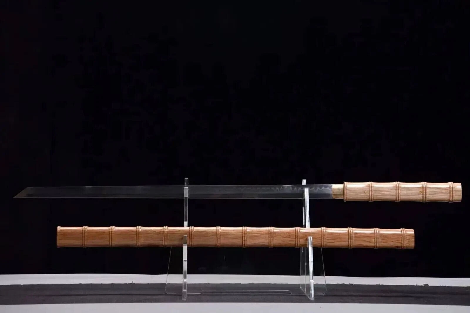 Shikomizue Katana A Shikomizue Katana sword displayed on a small stand next to its wooden scabbard.