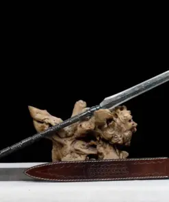 An all-steel short spear weapon, displayed on a wood log, with its leather sheath below on the floor.