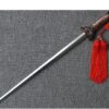 A retractable Taiji training sword laying on a carpet floor.