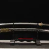 A Japanese Samurai Katana sword and its decorative scabbard displayed on a small wooden stand.
