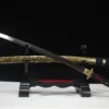 A Japanese Katana and its decorative scabbard, displayed on a small wooden sword stand.