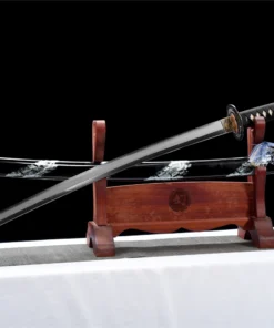 A T12A crane sword, displayed next to its decorative scabbard, on a small wooden Katana-stand.