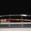 A real demon Katana slayer sword, displayed next to its decorative scabbard, on a small stand.