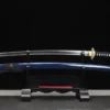 A water dragon Katana sword displayed next to its blue scabbard, on a small wooden sword-stand.
