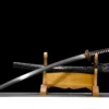 A Japanese Katana sword and its scabbard displayed on a wooden sword stand.