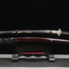 A Katana dragon sword and its scabbard displayed on a small wooden sword-stand.