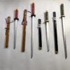 Four toy Katana swords of differing sizes and colors, next to their scabbards, displayed on the floor.