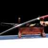 A decorative Koi Katana displayed next to its scabbard, on a small wooden sword-stand.
