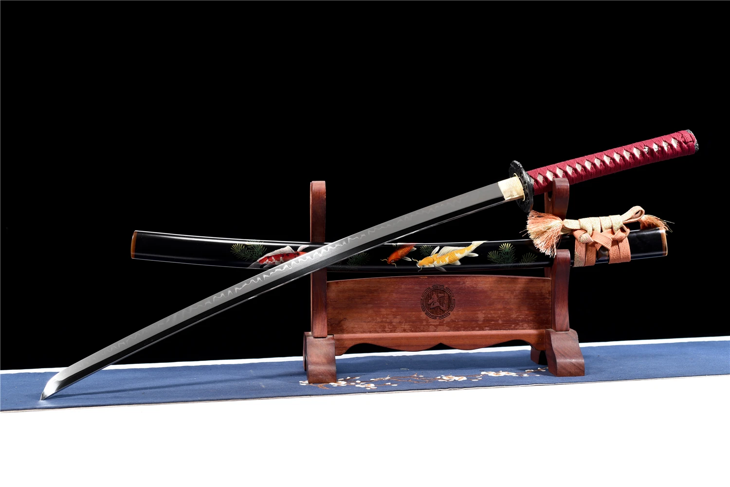 Koi Katana A decorative Koi Katana displayed next to its scabbard, on a small wooden sword-stand.
