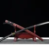 A manslayer Katana displayed crossed against its scabbard, leaning against a small wooden sword-stand.