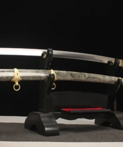 A WW2 Katana, navy officer sword and its decorated scabbard displayed on a small sword stand.