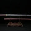A Shimomizue sword displayed next to its wood scabbard, on a small wooden sword-stand.