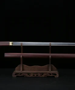 A Shimomizue sword displayed next to its wood scabbard, on a small wooden sword-stand.
