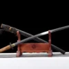 A Shinken Katana sword and its scabbard displayed on a small wooden stand.