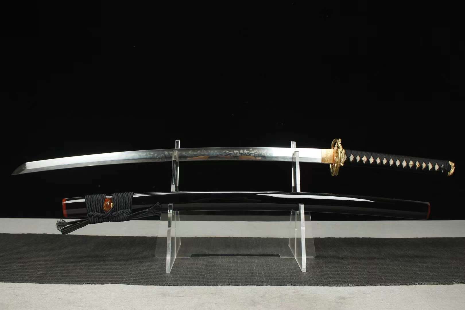Snake Sword A Japanese snake sword Katana displayed on a small stand alongside its scabbard.