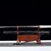 A single edged, straight blade Chokuto sword and its scabbard displayed on a wood stand.