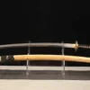 A T10 sword Katana displayed next to its wooden scabbard, on a small stand.