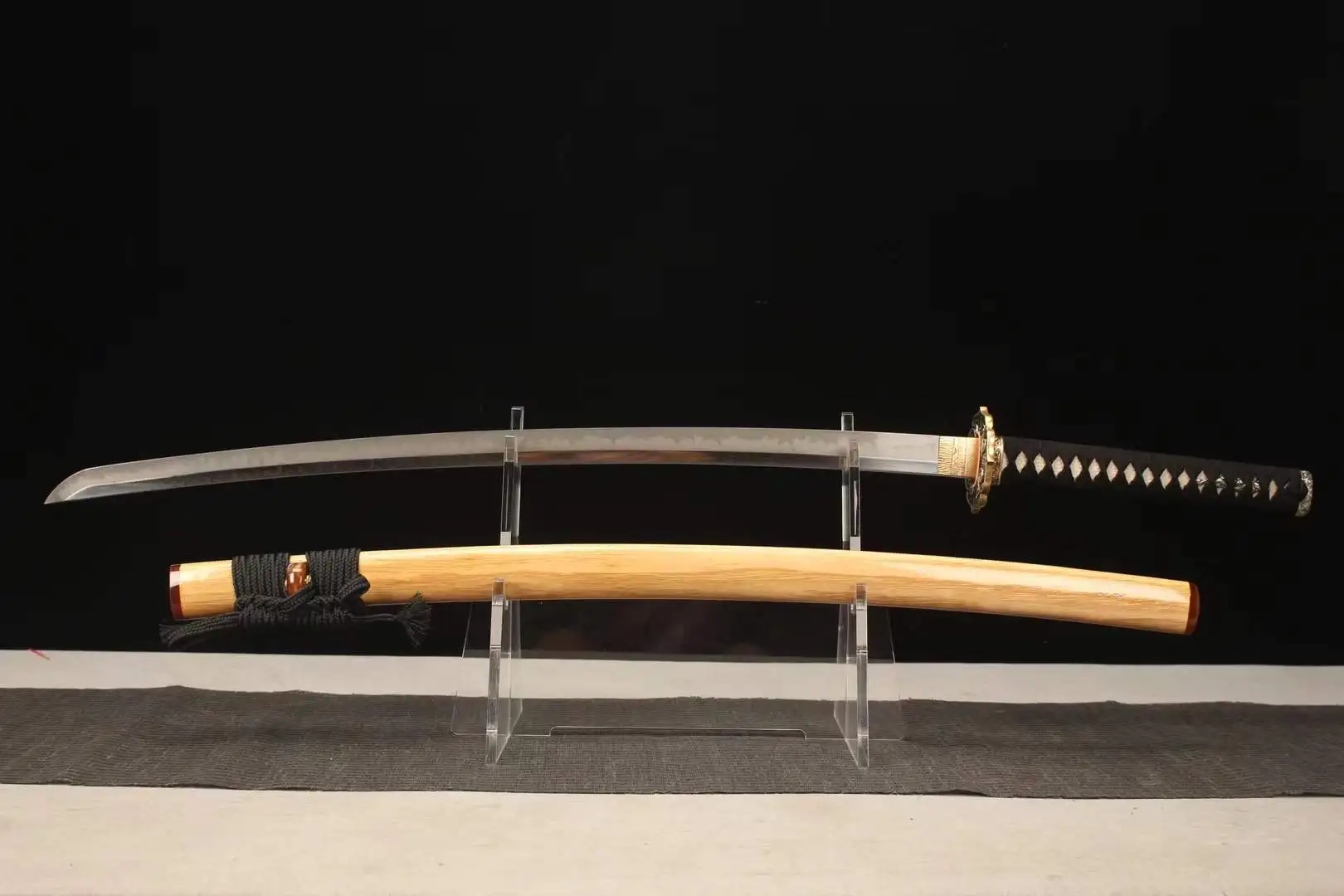 T10 Sword A T10 sword Katana displayed next to its wooden scabbard, on a small stand.