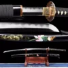 A floral sword Katana displayed next to its decorative scabbard, on a small wooden sword-stand.