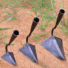 Three garden hand plow heads of differing size, displayed on earth ground.