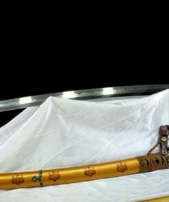 A Tachi horse sword displayed next to its decorative scabbard, on a white sheet.