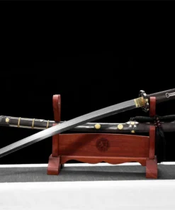 A Tachi Japanese cavalry sword displayed next to its decorative scabbard, on a small wooden stand.