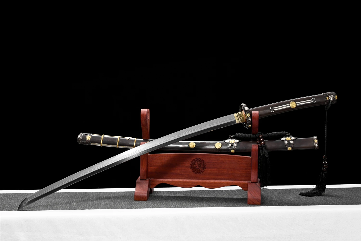 Japanese Cavalry Sword A Tachi Japanese cavalry sword displayed next to its decorative scabbard, on a small wooden stand.