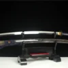 A Japanese Uchigatana sword and its beautiful scabbard displayed on a small wooden stand.