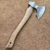 A stainless steel hatchet with a wooden handle displayed lying on a floor.