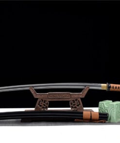 A broad Katana sword, displayed on a small wooden stand, with its scabbard below on the floor.