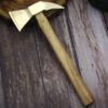 A small fire axe with a wood handle displayed on a wooden floor.