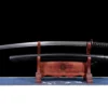 A dull Katana training sword displayed next to its black scabbard, on a small wooden stand.