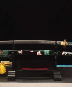 A Japanese dragon engraved Katana displayed next to its decorative flower & Koi illustrated scabbard, on a small wooden stand.