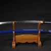 A folded steel Iaido sword and its blue colored scabbard displayed on a small wooden stand.