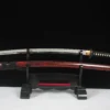 A full tang Katana displayed next to its scabbard, on a small wooden sword-stand.