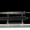 A modern gladius sword, displayed next to its sheath, on a small stand.