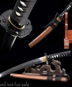 A Samurai Tanto knife displayed leaning against a small wooden stand, alongside its wooden sheath.