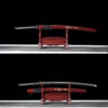 Two Japanese Samurai Katanas, with one displayed sheathed on a wooden sword stand, and the second displayed unsheathed, next to its scabbard.
