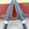 Two multifunctional survival spear heads leaning against a wall.