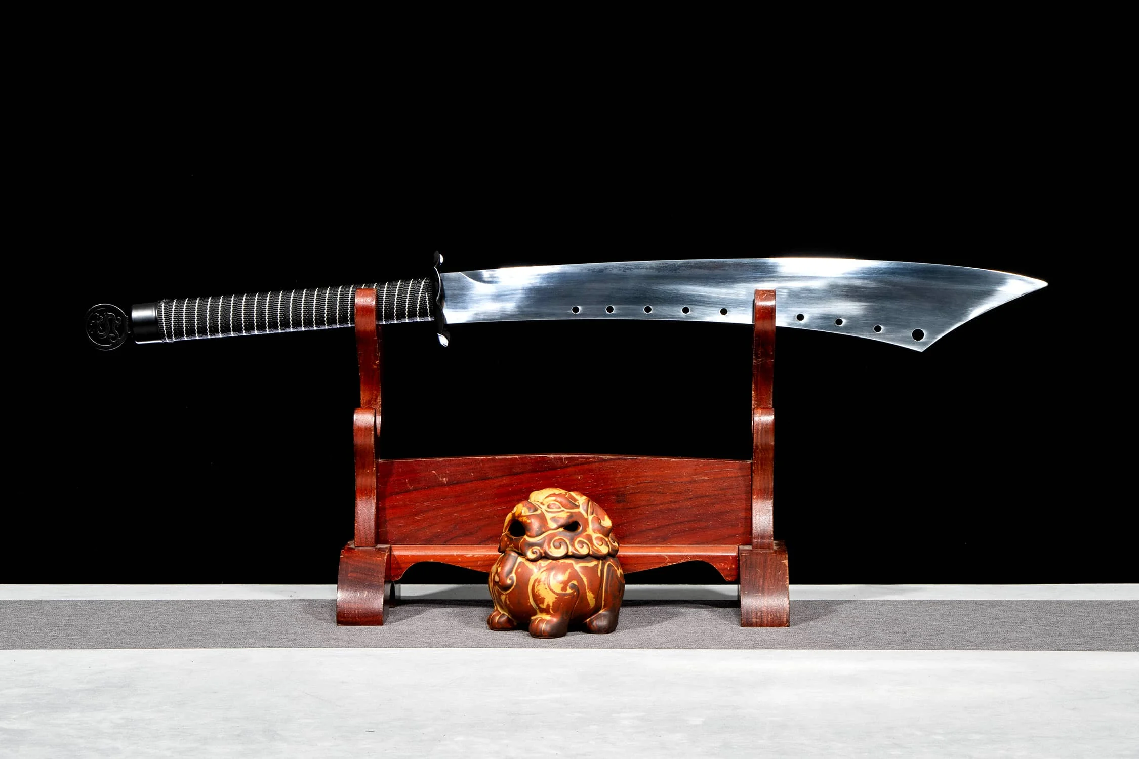 Chinese Ring Sword A Chinese ring sword displayed on a small wooden sword-stand.