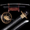 A Daito Katana sword displayed alongside its black scabbard, on a wooden sword stand, along with sword highlights below.