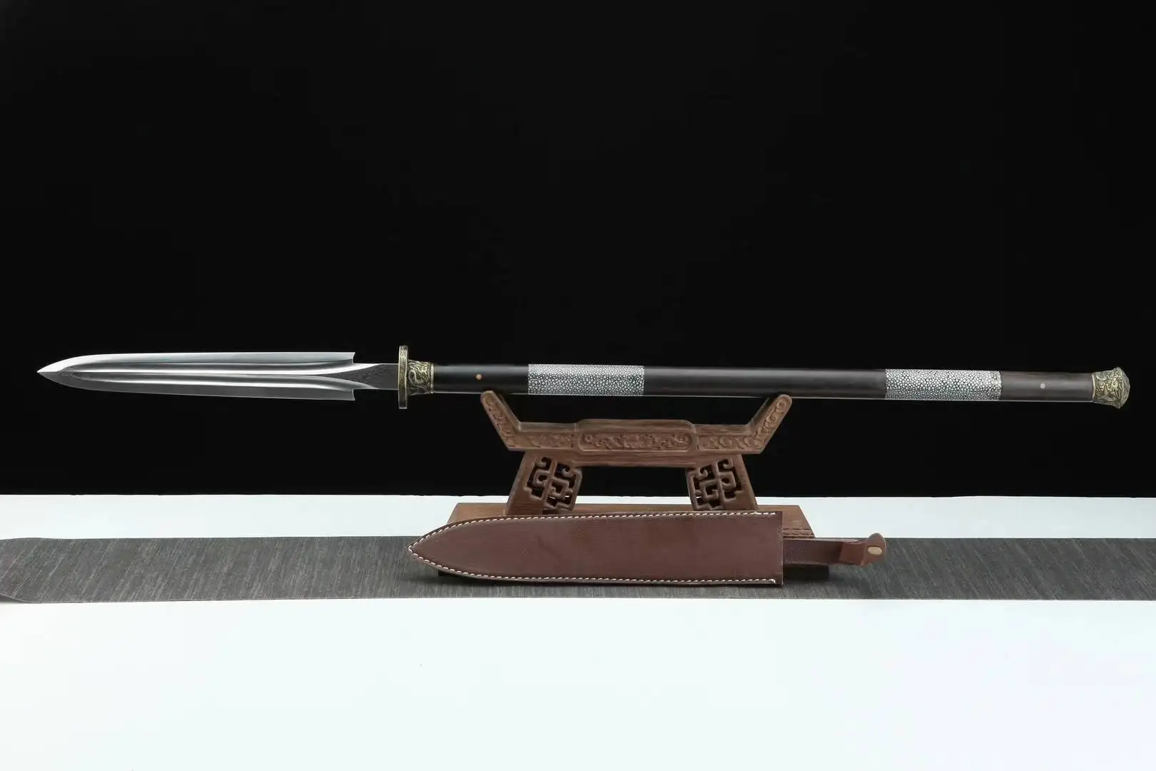 One Handed Spear A one handed spear with a double edged spearhead, displayed on a small wooden stand.