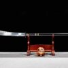 A two handed pole sword displayed on a wooden stand.