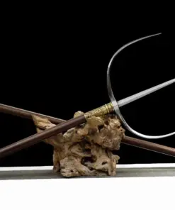 A Chinese tiger fork weapon, displayed next to its handle attachment, on a small wood log.