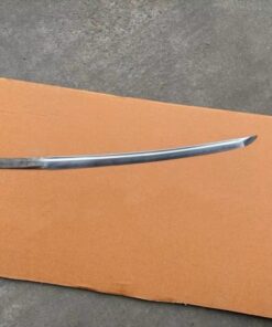 A Wakizashi blade blank, lying on a sheet of cardboard, on the floor.